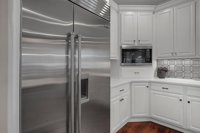2443 Shepherd Ct, Powell, OH 43065 - kitchen with high quality fridge, black microwave, white cabinetry, light countertops, and dark wood-style floors