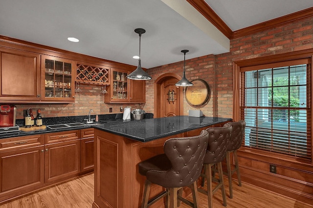 2443 Shepherd Ct, Powell, OH 43065 - indoor wet bar with brick wall, light wood-type flooring, decorative light fixtures, and crown molding