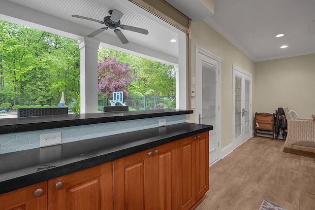 2443 Shepherd Ct, Powell, OH 43065 - kitchen featuring light wood-type flooring, brown cabinetry, crown molding, recessed lighting, and dark countertops
