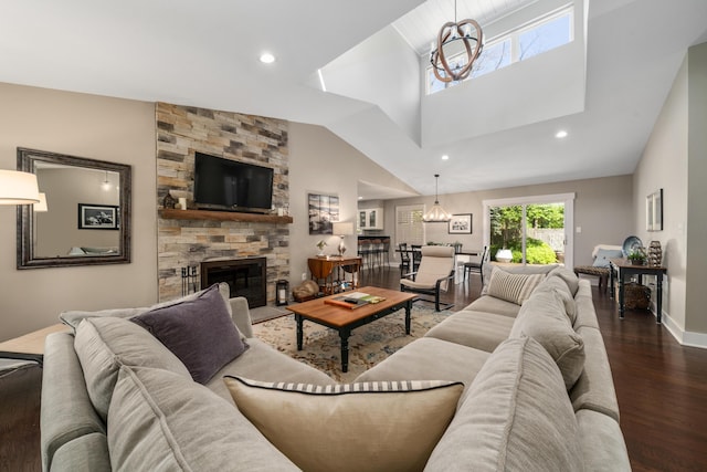 living area featuring a stone fireplace, recessed lighting, baseboards, and wood finished floors
