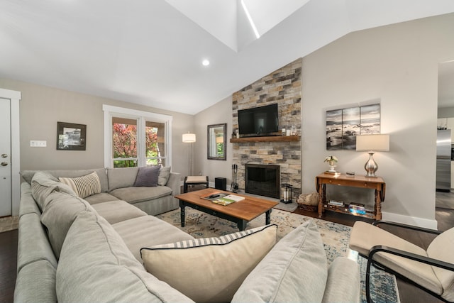 living room with a stone fireplace, a skylight, wood finished floors, baseboards, and high vaulted ceiling