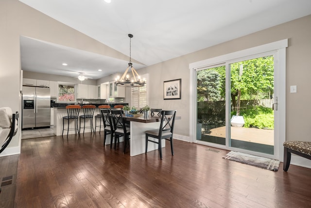 dining space featuring an inviting chandelier, recessed lighting, baseboards, wood finished floors, and vaulted ceiling