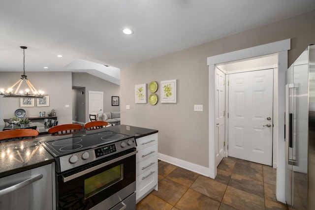 kitchen featuring dark countertops, an inviting chandelier, stainless steel appliances, decorative light fixtures, and white cabinetry