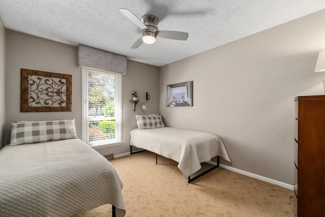 bedroom featuring baseboards, a ceiling fan, a textured ceiling, and light colored carpet