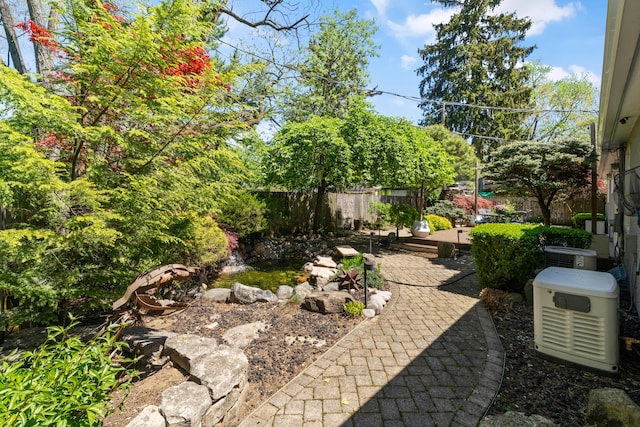 view of yard with a fenced backyard, a patio, and central AC