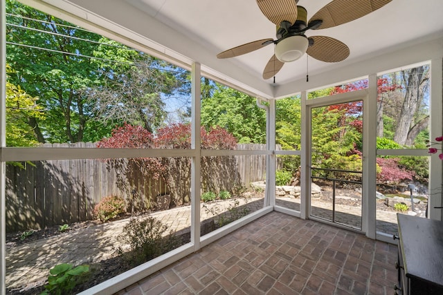 unfurnished sunroom featuring ceiling fan