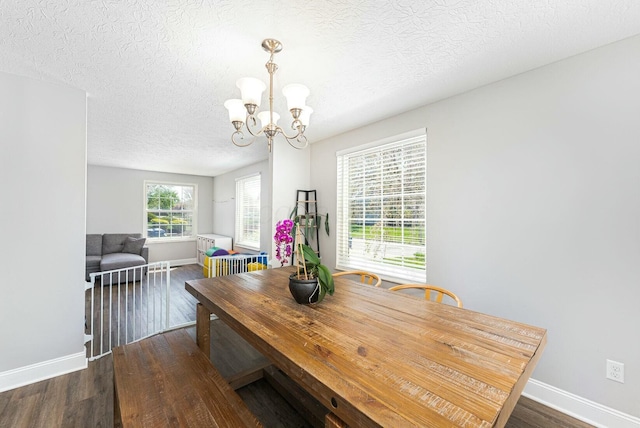 dining area featuring baseboards, wood finished floors, and an inviting chandelier