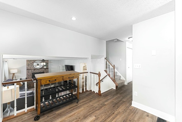 interior space featuring a textured ceiling, ceiling fan, baseboards, recessed lighting, and wood finished floors