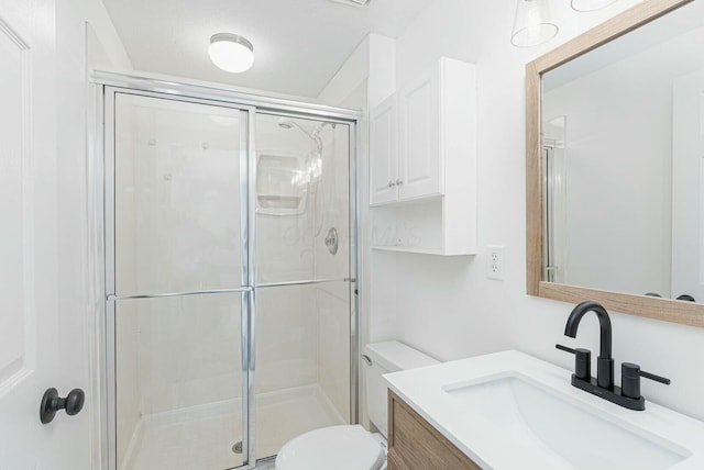 bathroom featuring vanity, toilet, and a stall shower