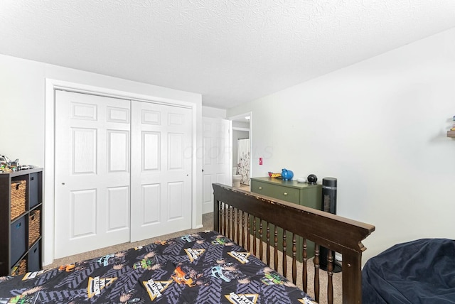 bedroom with a textured ceiling, a closet, and carpet flooring