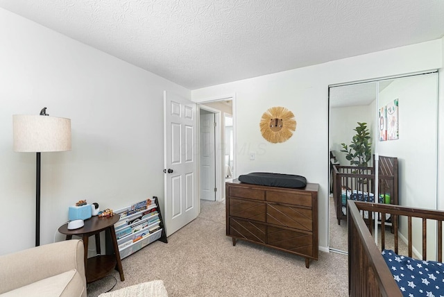 bedroom with a textured ceiling and light colored carpet