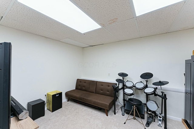 living area with baseboards, carpet flooring, and a paneled ceiling