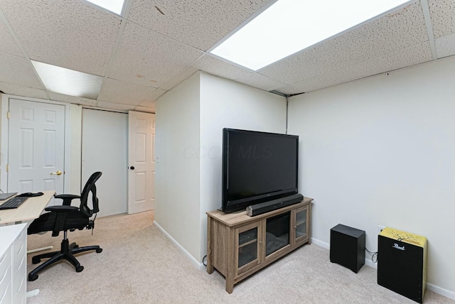 office area with a drop ceiling, baseboards, and light carpet