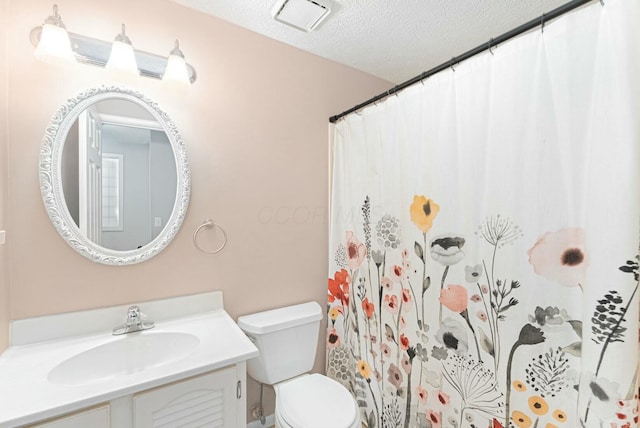 bathroom with vanity, toilet, visible vents, a textured ceiling, and a shower with shower curtain