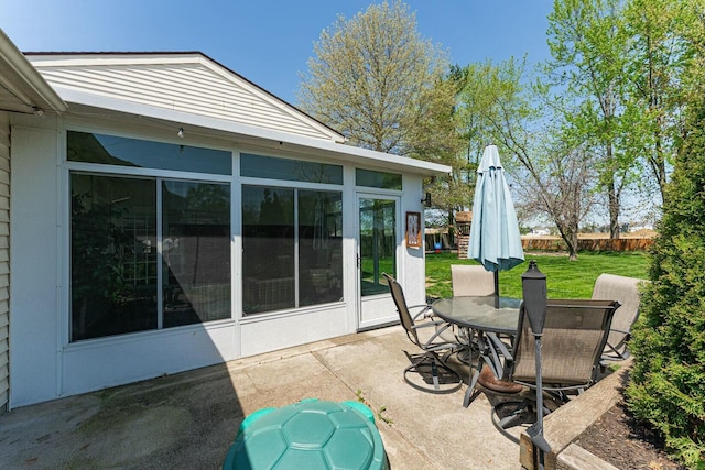 view of patio / terrace featuring outdoor dining area and a sunroom