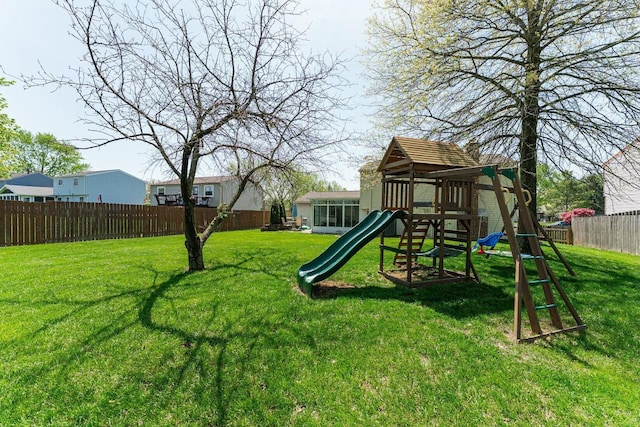 view of jungle gym featuring fence private yard and a lawn