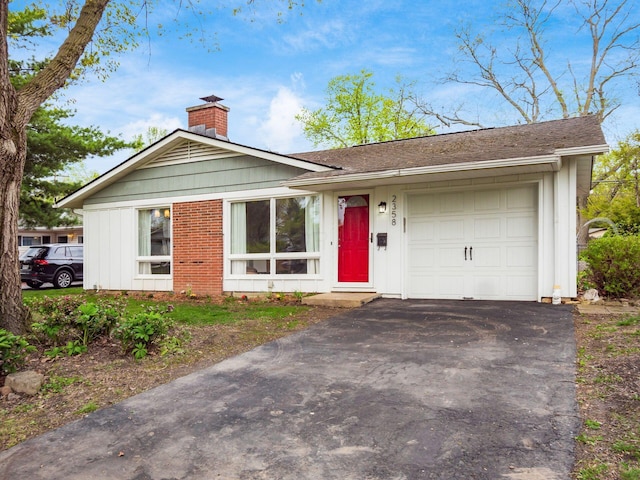 view of front of home featuring driveway, a chimney, board and batten siding, and a garage