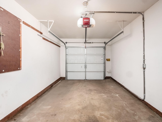 garage with a garage door opener and baseboards