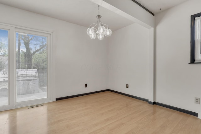 unfurnished room featuring visible vents, baseboards, an inviting chandelier, and light wood finished floors