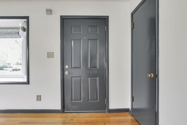 foyer entrance featuring light wood-style floors and baseboards