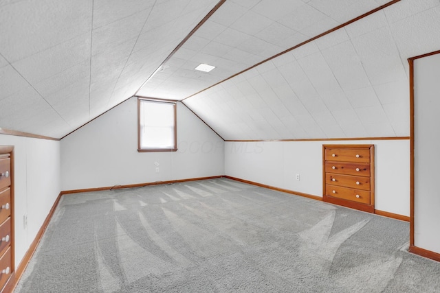 additional living space featuring carpet floors, baseboards, and lofted ceiling