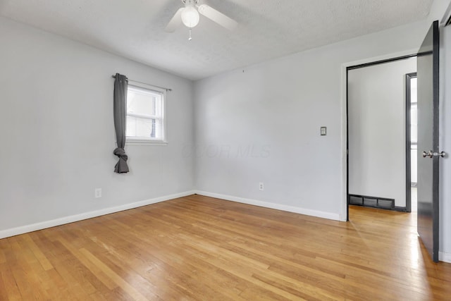 spare room with a ceiling fan, baseboards, and light wood-type flooring