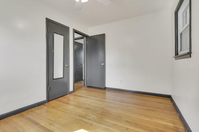 spare room with a ceiling fan, baseboards, and light wood finished floors