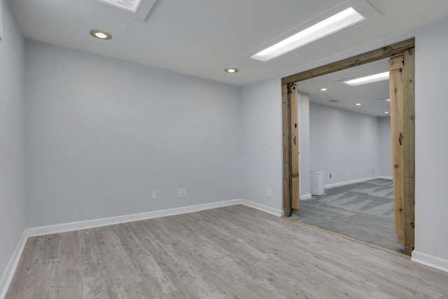 empty room with baseboards, recessed lighting, and wood finished floors