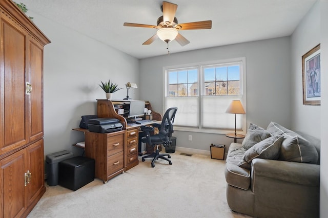 office with a ceiling fan, baseboards, visible vents, and light carpet