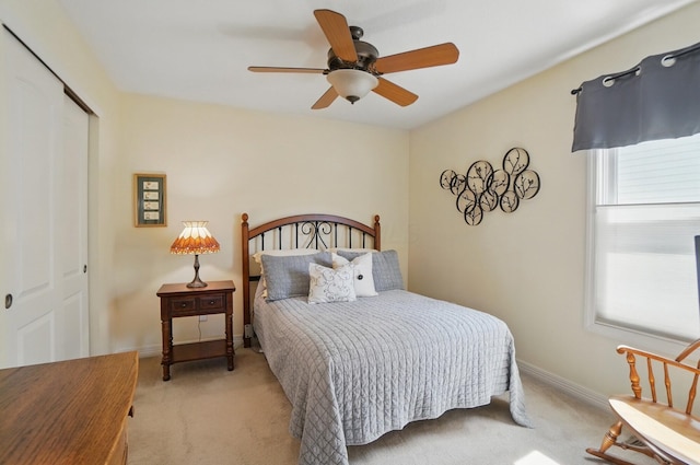 carpeted bedroom featuring a ceiling fan, baseboards, and a closet