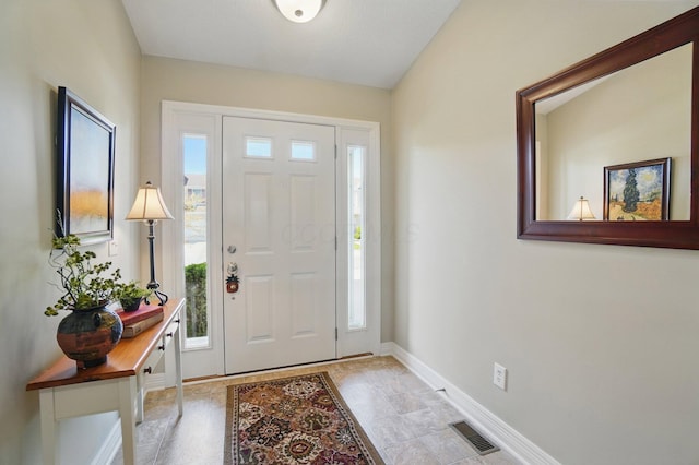 foyer entrance with visible vents and baseboards