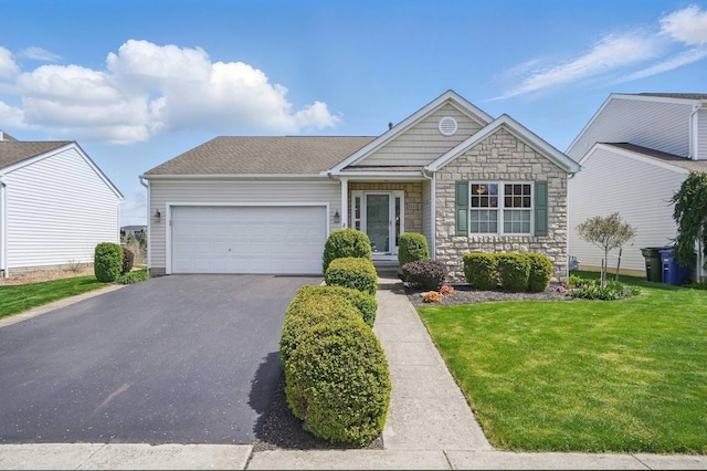 view of front of house with a front yard, an attached garage, driveway, and stone siding