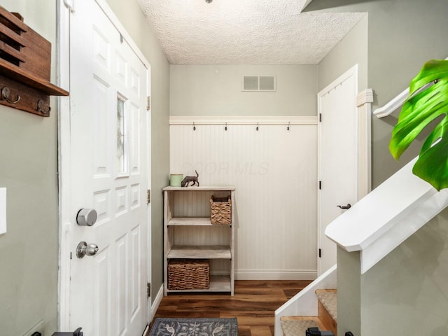 mudroom with baseboards, visible vents, wood finished floors, and a textured ceiling