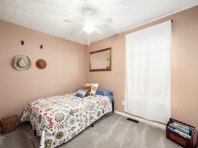 bedroom featuring a textured ceiling, carpet flooring, ceiling fan, and visible vents