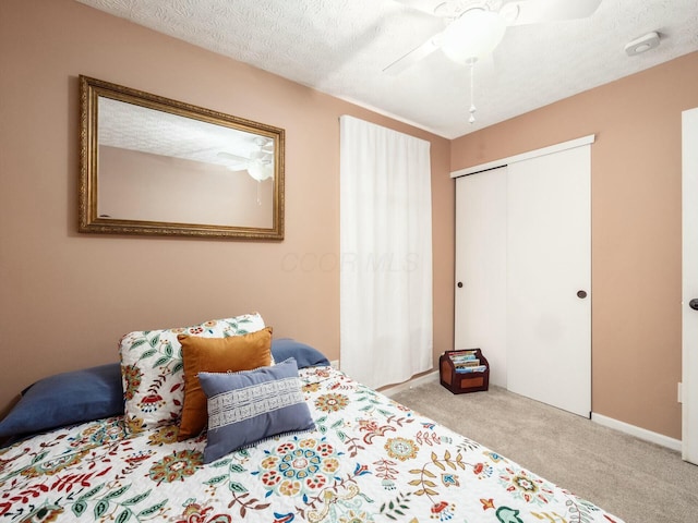 carpeted bedroom featuring ceiling fan, baseboards, and a closet