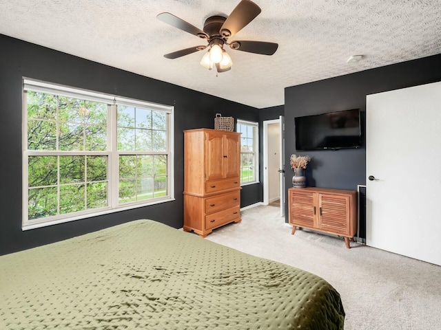 bedroom featuring light carpet, a textured ceiling, and ceiling fan