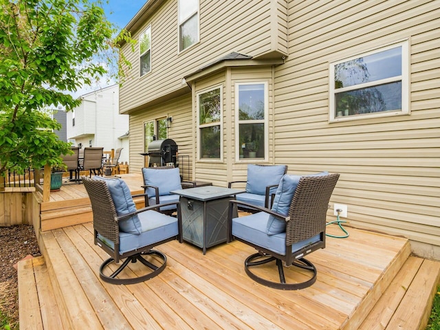wooden terrace featuring outdoor dining space and an outdoor living space with a fire pit