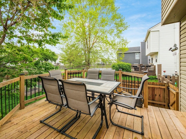 deck with outdoor dining area and a fenced backyard