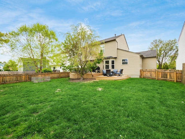 back of house with a wooden deck, a yard, and a fenced backyard