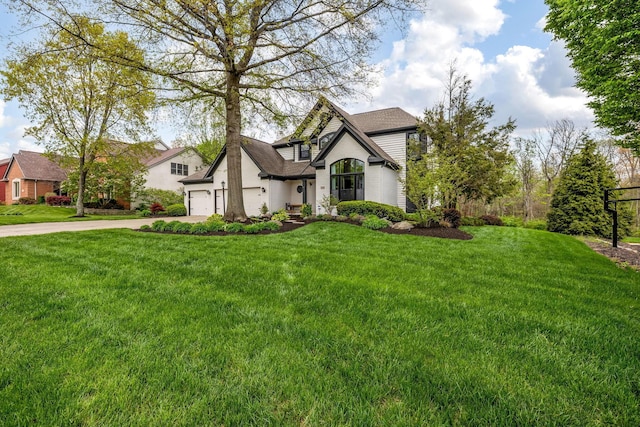 view of front of house with a garage, a shingled roof, driveway, and a front yard