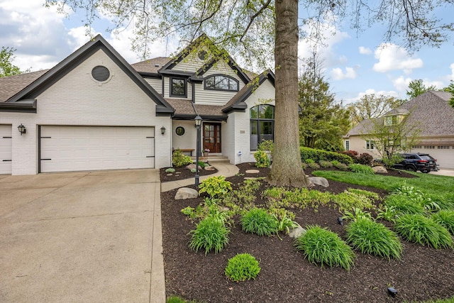 traditional-style home with a garage, concrete driveway, roof with shingles, and brick siding