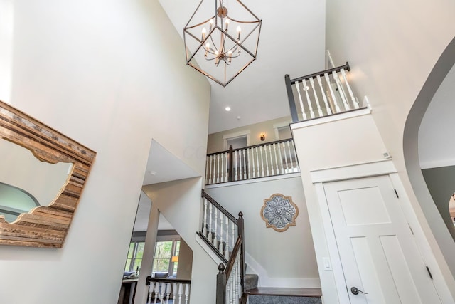 stairs featuring arched walkways, a high ceiling, and an inviting chandelier