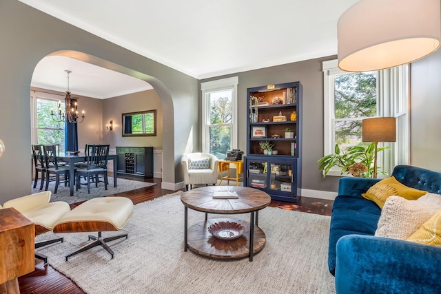 living area with an inviting chandelier, arched walkways, and a wealth of natural light