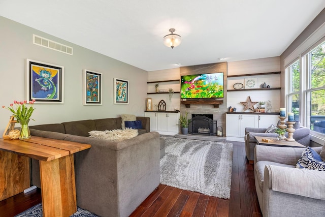 living room featuring a fireplace, dark wood finished floors, and visible vents