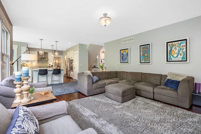 living area with dark wood finished floors and visible vents