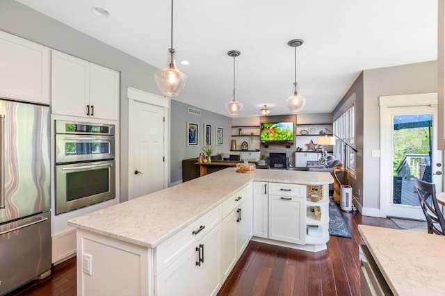 kitchen with dark wood-style flooring, visible vents, white cabinets, open floor plan, and stainless steel appliances