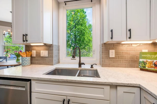 kitchen with a sink, dishwasher, white cabinets, and tasteful backsplash