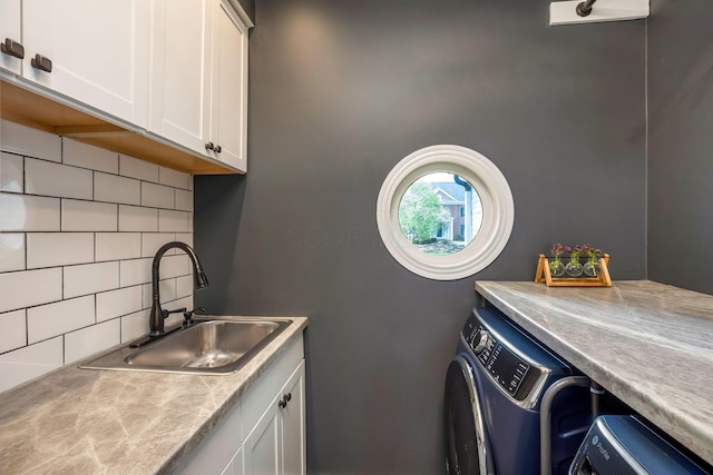 laundry room with a sink, cabinet space, and washer and dryer