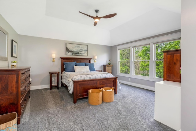 bedroom with ceiling fan, a raised ceiling, baseboards, lofted ceiling, and dark carpet