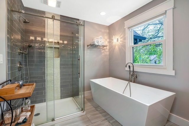 bathroom with a freestanding bath, recessed lighting, baseboards, a shower stall, and visible vents